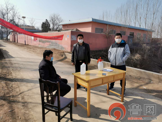 第一书记李国栋(右)在村口防控一线菏泽一中派驻柳庄行政村第一书记