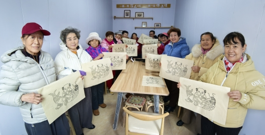 指导员在社区建立“家门口的非遗体验站”，居民在社区体验年画非遗